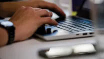 Closeup shot of hands typing on a laptop