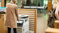 Woman using colour printer in school