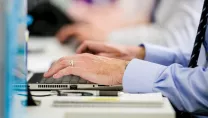 Close up of hands typing on a keyboard