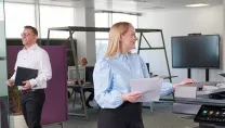 Colleagues talking at office printer