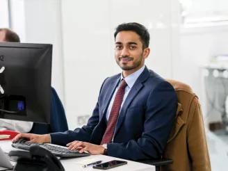 A man sat at a desk looking at the camera