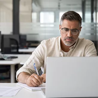 Man Looking at Laptop with Headphones