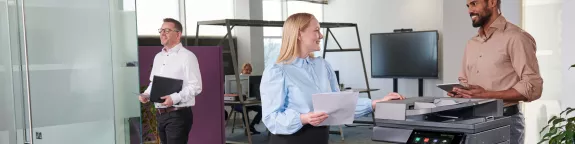 Colleagues talking at office printer