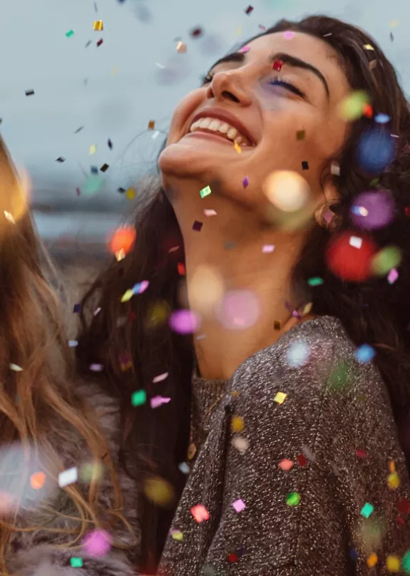 Four women celebrating with confetti